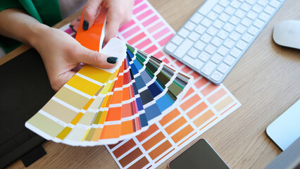 Interior designer holding fan of multicolored samples