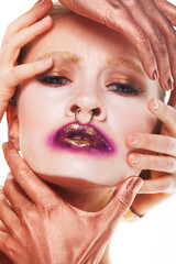 Young woman with fantasy bright make up. Several hands hug the face.