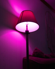 Magenta lit lamp at night.