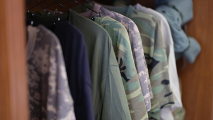 Fototapeta na wymiar Collection of military uniform tshirts in wardrobe