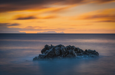 Fototapeta na wymiar Sunrise on Reis Magos beach. Canico, Madeira, Portugal. October 2021. Long exposure picture