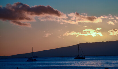 Hawaiian sunset with boats and surfers, Oahu, Hawaii