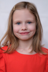 Little smiling girl posing and looking at camera with gladness