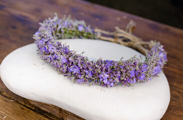 jewelry, manual work. The main object is in focus. soft focus. Wreath on the head, with dry purple flowers. head decoration