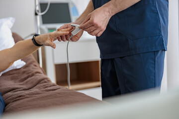 Nurse checking with fingertip pulse oximeter oxygen saturation of patient blood. High quality photo