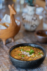 Quinoa stew with vegetables and beef llama in a rustic black stoneware pot. Traditional Latin American food. Salta, Argentina.