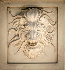 Tan Colored Lion Head Exterior Wall Decoration on Building Wall
