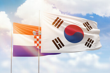 Sunny blue sky and flags of south korea and croatia