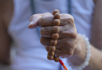 Closup buddhist man holding rosary and amulet of thailand