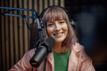 Portrait of female radio host speaking in microphone while moderating a live show