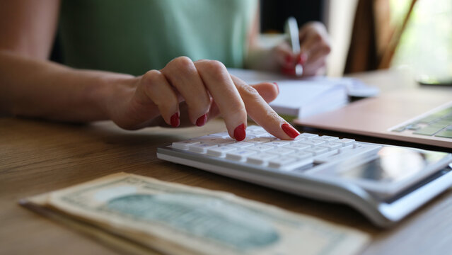Woman doing calculation of expenses and income and making notes