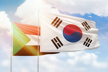 Sunny blue sky and flags of south korea and sudan