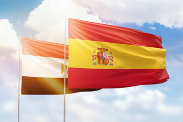 Sunny blue sky and flags of spain and egypt