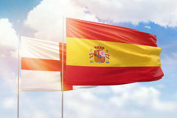 Sunny blue sky and flags of spain and england