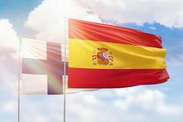 Sunny blue sky and flags of spain and finland