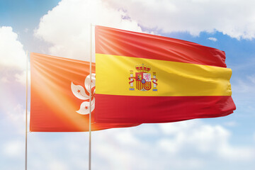 Sunny blue sky and flags of spain and hong kong