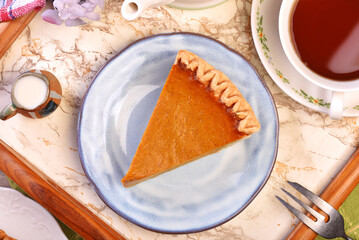 A slice of delicious pumpkin pie served on table 