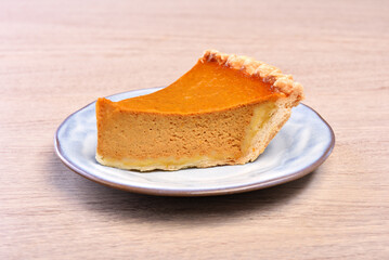 A slice of delicious pumpkin pie served on table 