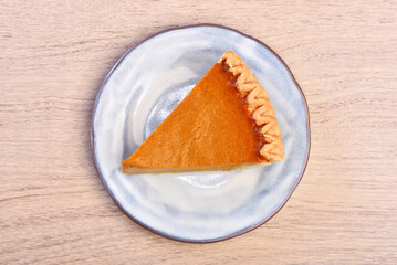 A slice of delicious pumpkin pie served on table 