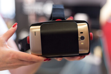 Female holds VR glasses with a smartphone. Test drive option to try out VR technology.