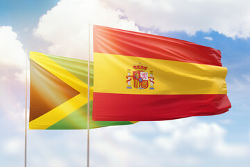 Sunny blue sky and flags of spain and jamaica