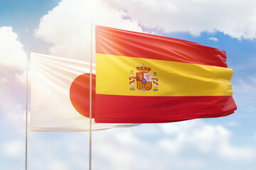 Sunny blue sky and flags of spain and japan