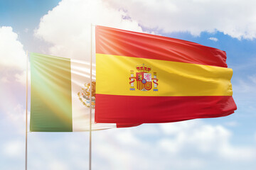 Fototapeta premium Sunny blue sky and flags of spain and mexico