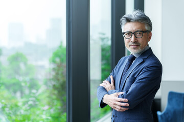 窓辺に立つミドルビジネスマンのポートレート