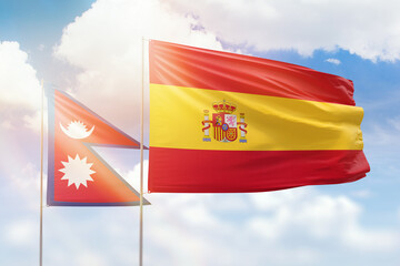 Sunny blue sky and flags of spain and nepal