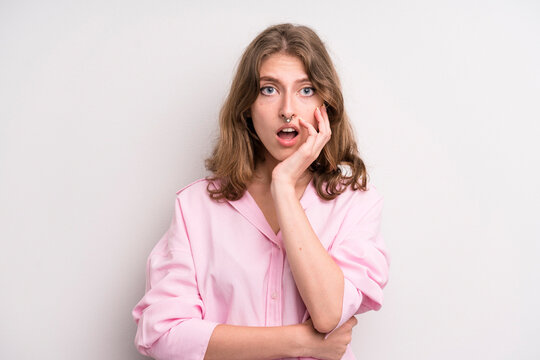 teenager young girl open-mouthed in shock and disbelief, with hand on cheek and arm crossed, feeling stupefied and amazed