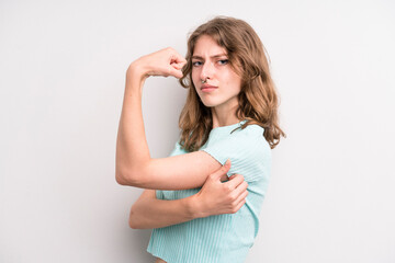 teenager young girl feeling happy, satisfied and powerful, flexing fit and muscular biceps, looking strong after the gym