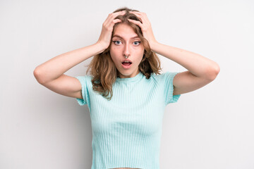 teenager young girl feeling horrified and shocked, raising hands to head and panicking at a mistake