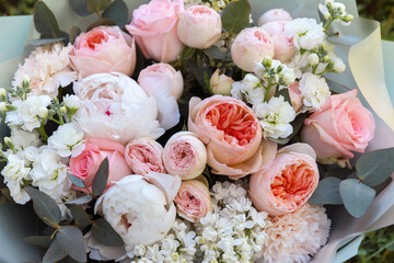 Beautiful rich elegant wedding pink white bouquet, flowers arrangement by florist with roses, peony, lilac, leaves and flowers. Floral background