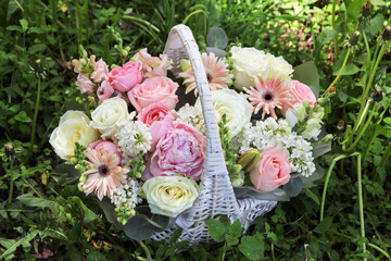 Beautiful rich elegant wedding pink white bouquet in basket, flowers arrangement by florist with roses, lilac, peony, leaves and flowers. Floral background