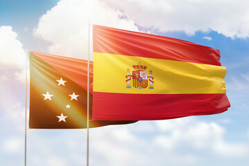 Sunny blue sky and flags of spain and papua new guinea