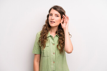 young adult pretty woman looking serious and curious, listening, trying to hear a secret...