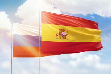 Fototapeta premium Sunny blue sky and flags of spain and russia