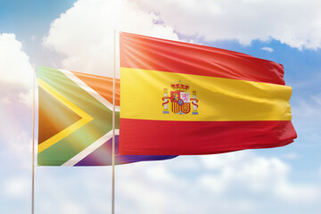 Sunny blue sky and flags of spain and south africa