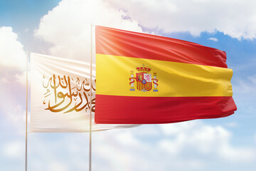 Sunny blue sky and flags of spain and afghanistan