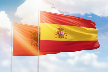 Sunny blue sky and flags of spain and albania