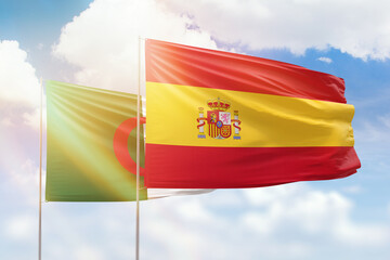 Sunny blue sky and flags of spain and algeria