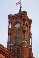 View of tower and clock of Rotes Rathaus in summer, the famous red town hall of Berlin with clouds in blue sky background.