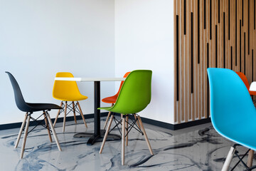 a modern cafe with colorful chairs and white tables. Lounge bar