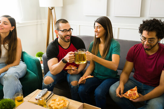 Cheerful Friends Drinking Beer And Hanging Out In The Living Room