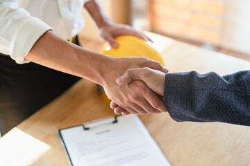 close up view hands of agent and client shaking hands after signed contract buy new apartment.