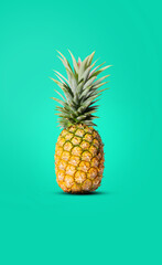 yellow pineapple mixed with green put on a green background The perfect fruit for a summer at the beach.