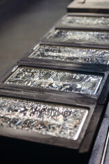Silver bars chill down in graphite casting forms on table