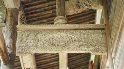 The old wooden Chinese architecture with the wood sculpture on the columns