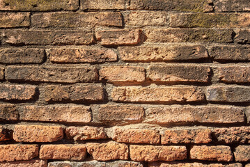 Old red brick stone wall exterior on ancient temple architecture in Ayutthaya, Thailand.