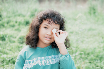 Portrait of a young Asian woman with curly hair with various facial expressions in the park in the morning